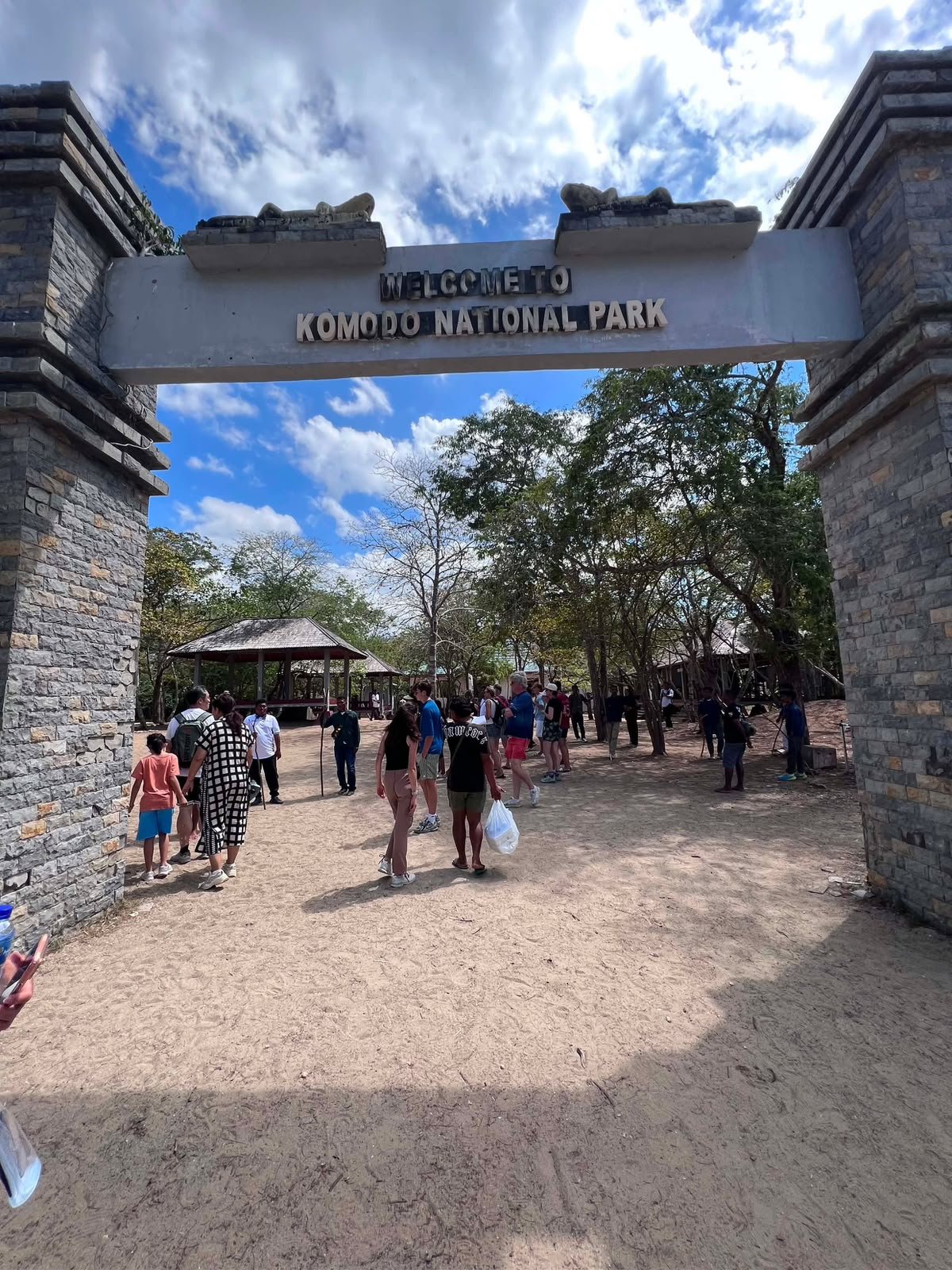 Visitors walking through the stone entrance gate of Komodo National Park